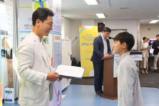 이승찬(왼쪽) 계룡장학재단 이사장이 9일 대전지역 초·중학생 48명과 지도자 3명에게 총 1300여만원의 장학금과 격려금을 전달하고 있다. [계룡건설 제공]